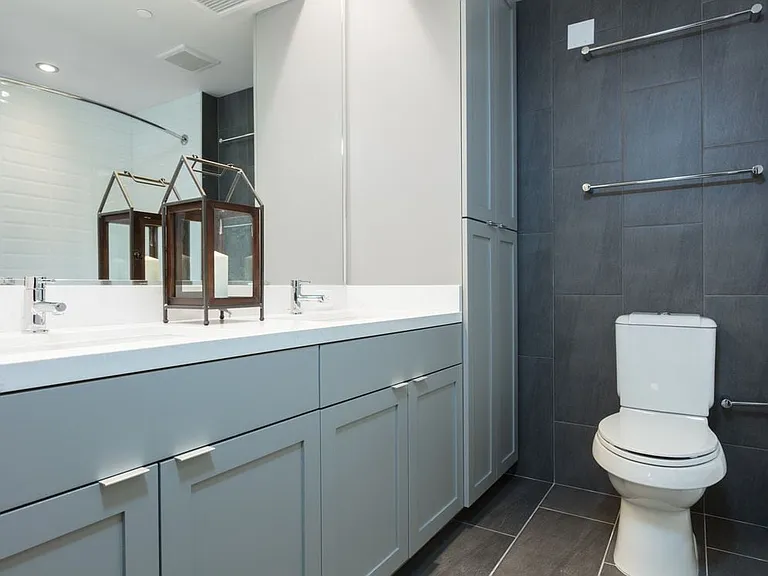 Signature Collection bathroom with double vanity, white countertop, grey cabinetry and tile flooring