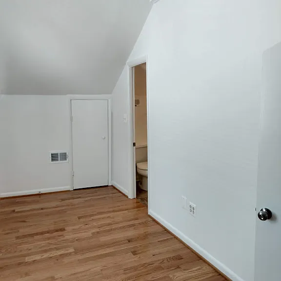 Bedroom with cathedral ceiling. Entrance to bathroom is to the right.