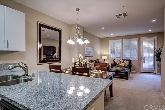 Kitchen, dining and open living area, with balcony in the background.