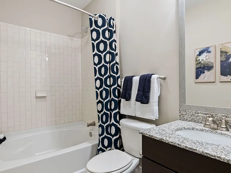 Bathrooms with granite countertops and ceramic tile flooring and tub enclosures