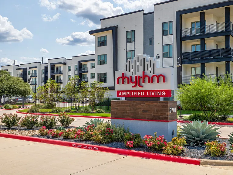 Rhythm Exterior Sign with landscaping and oversized balcony