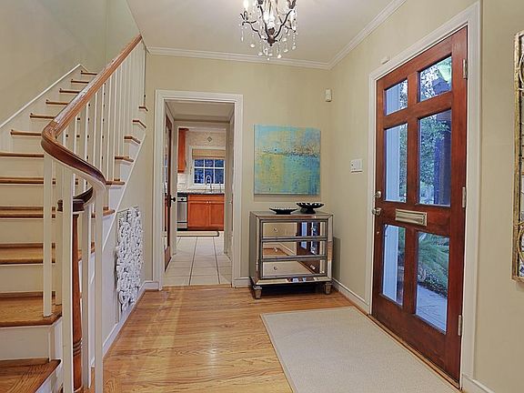 Light filled foyer with crystal chandelier, gorgeous original hardwoods and classic staircase.