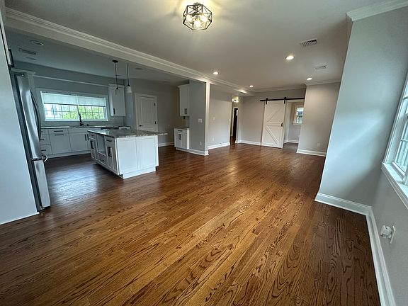 Bright open-concept layout with recessed lighting and rich hardwood floors throughout.