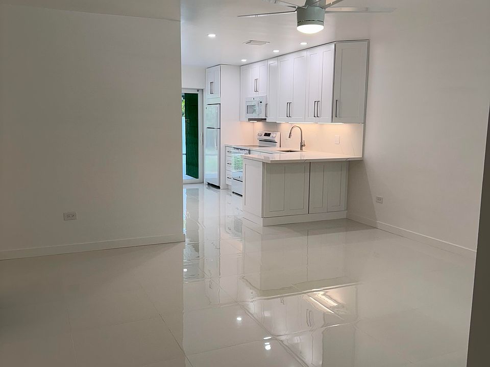 Front entrance looking at the living room, new open kitchen with Quartz countertop and hurricane proof sliding glass doors to the Florida Room and backyard.