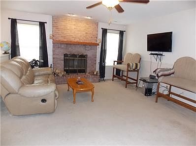 Spacious living room with wood burning fireplace.