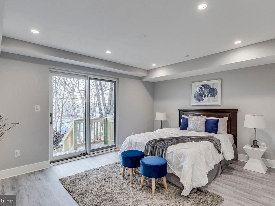 Primary bedroom with large windows and recessed lighting