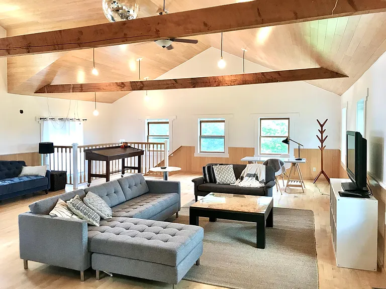 Loft space with vaulted ceilings, multiple sitting areas, a work space, a Roku-enabled large-screen TV, a sofa combination that would sleep two more