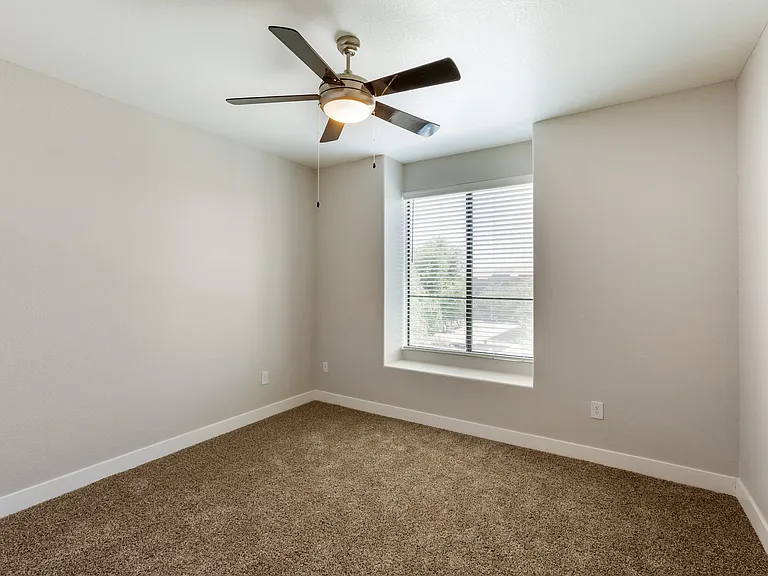 Relax in this serene bedroom with a ceiling fan and sunlit window