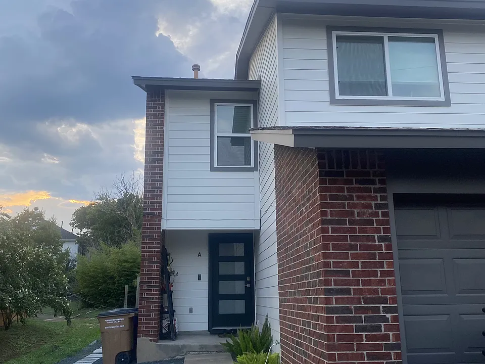 Updated siding, windows, front door, and black gravel front yard