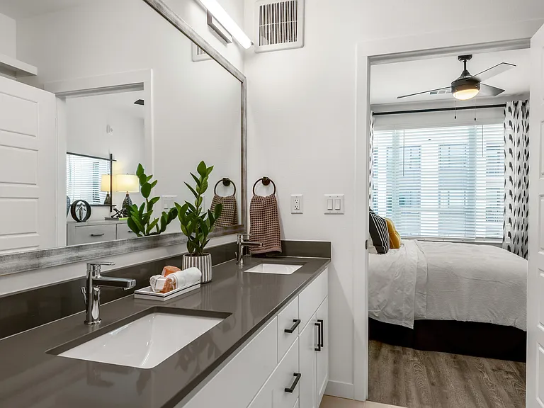 Modern Double Vanity with Sleek Countertops and Bedroom View