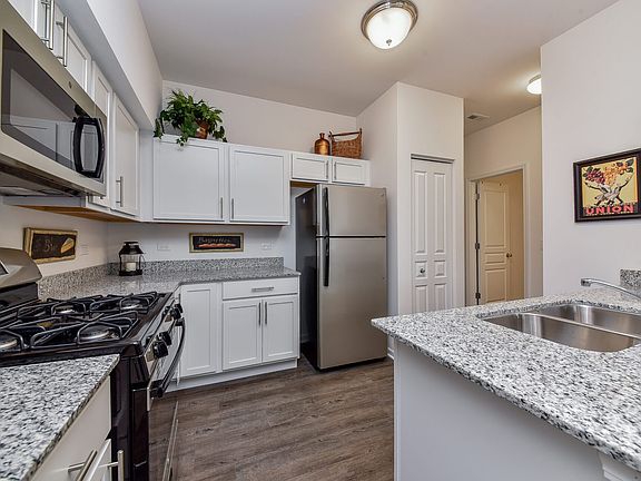 Kitchen with stainless steel appliances, granite counters, and white cabinets.