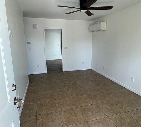 Front-door entrance to living room. A/C unit and entry to kitchen/dining area