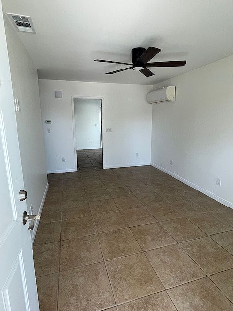 Front-door entrance to living room. A/C unit and entry to kitchen/dining area