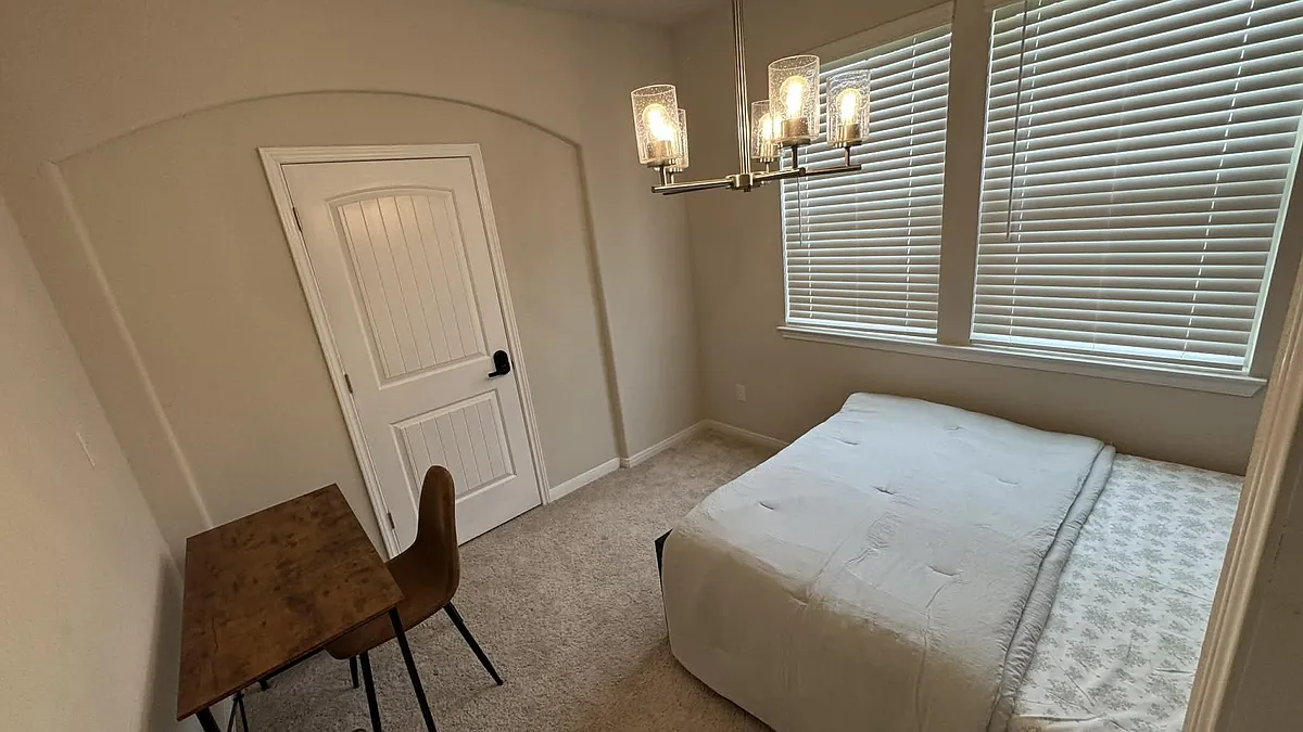 Photo 2 of 10 - Basil Beebalm Trl - Magnolia, TX Furnished bedroom featuring a bed, work desk, and large windows with blinds for light control and privacy. - Basil Beebalm Trl