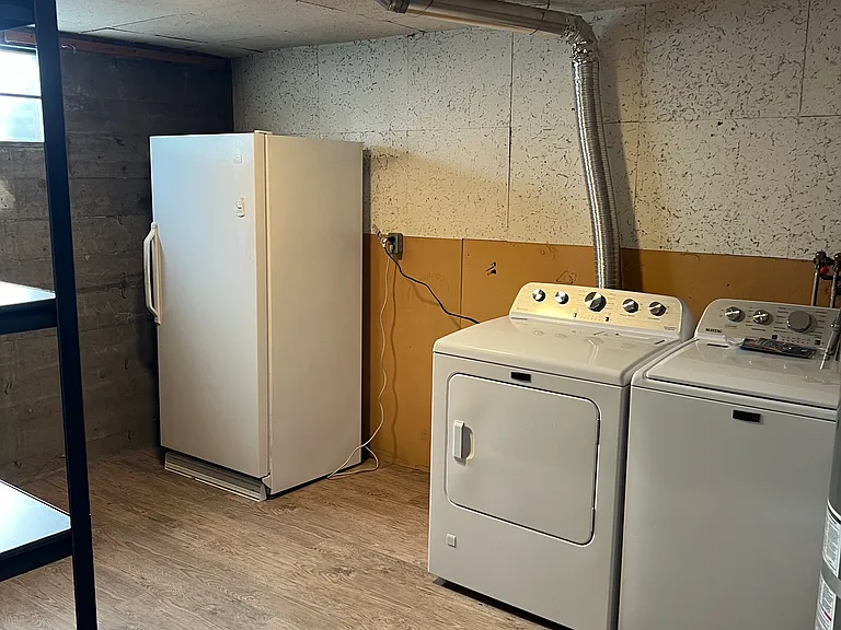 Laundry room with brand new Maytag washer/dryer, extra freezer/fridge space, shelving and plenty of storage.