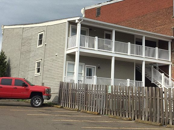 Rear with double-story porch and parking lot
