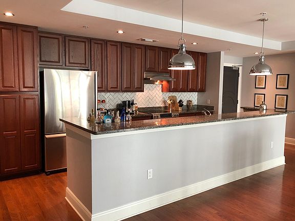 Kitchen with dark granite, custom backsplash, and stainless steel appliances. Modern cabinetry with plenty of storage space.