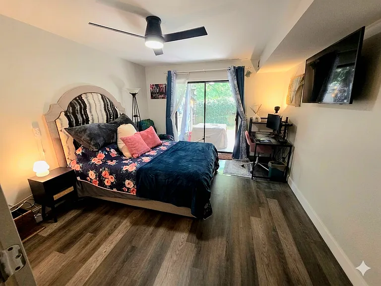Bedroom 1 with a sliding door to the private patio/fenced in backyard