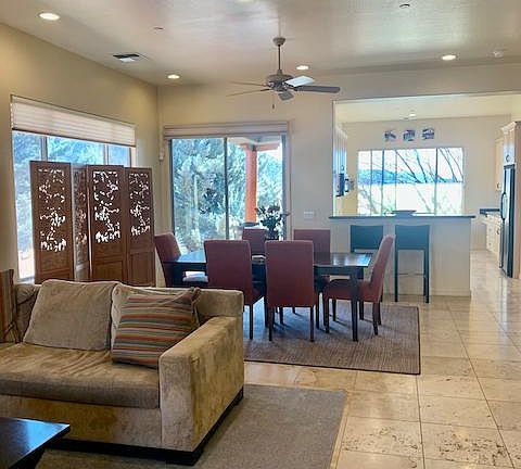Living room looking into dining & kitchen (couch & 2 area rugs, dining set furnished)