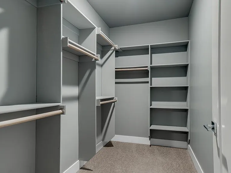 Keep your wardrobe organized with a spacious walk-in closet designed for convenience.