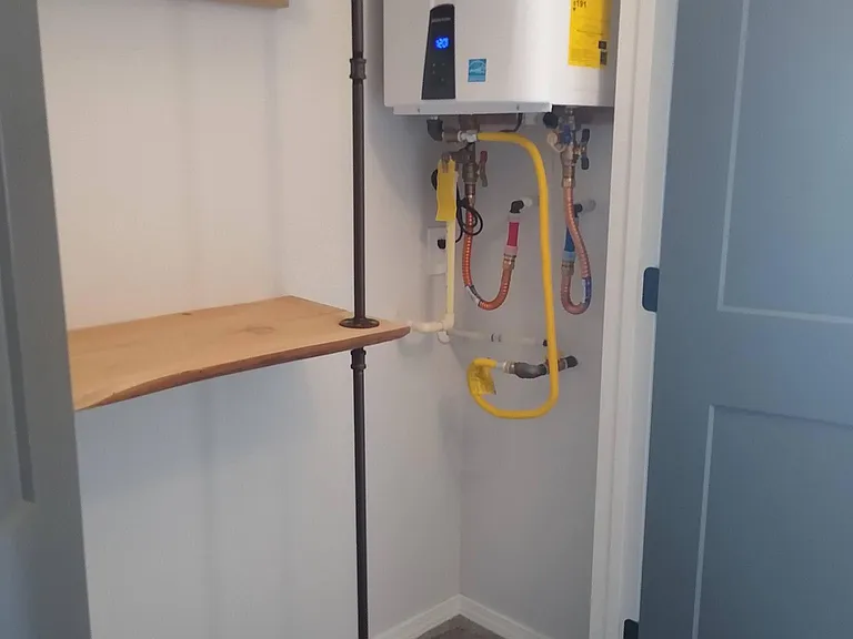 Upstairs hall closet with inston demand natural gas hot water heater