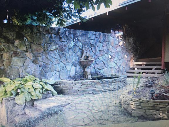front with great stone work and fountain that has rustic feel