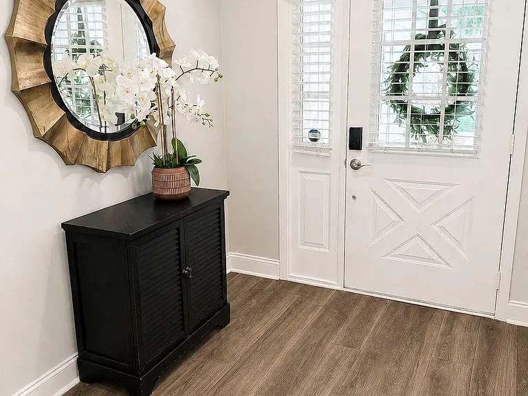 Welcoming entryway with wood-look flooring, side-light window, and space for a console cabinet or drop zone by the door.