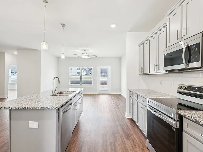Sleek modern kitchen with white cabinetry and granite countertops.