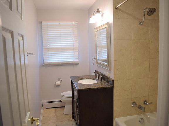 Full bath with travertine back splash and quartz countertop