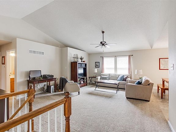Large open living room with vaulted ceilings, fresh paint, and new carpet