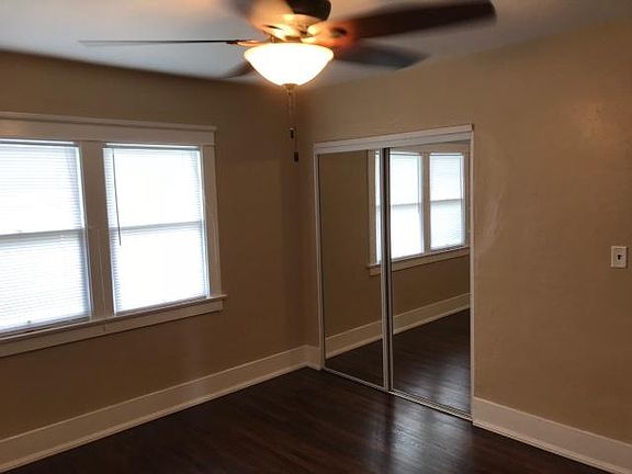 Mirrored closet doors and fan in bedroom