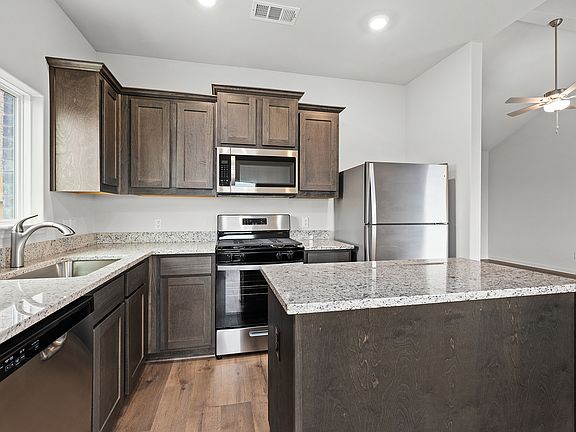 The kitchen has gorgeous wood cabinetry.