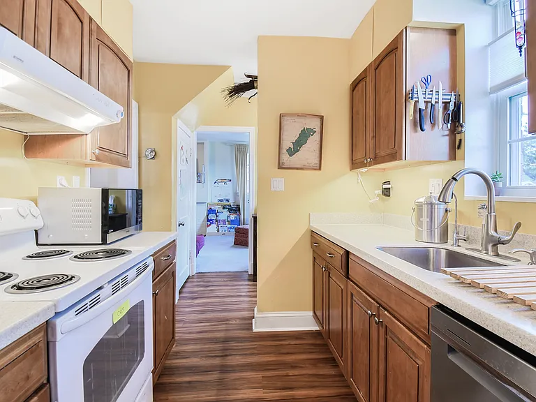 Kitchen from north entry door. Stainless steel sink and dishwasher (new, Feb 2025). Electric cooktop an oven.