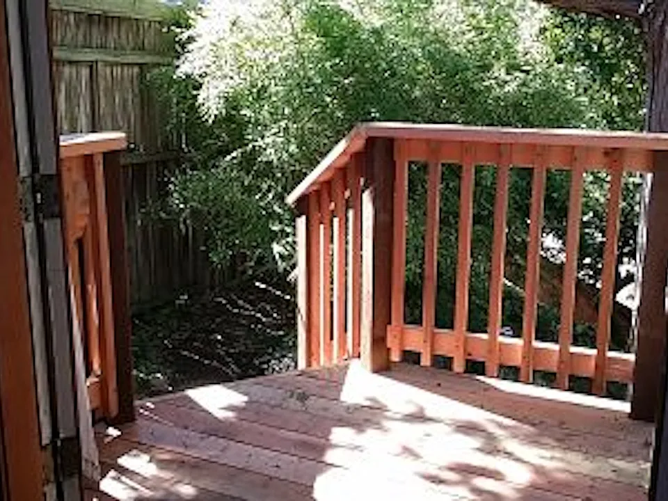Redwood deck and stairs frame the entry.