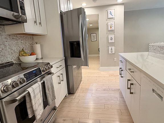 Kitchen - White granite countertops, recessed lighting, cabinets w/ custom Elfa storage systems