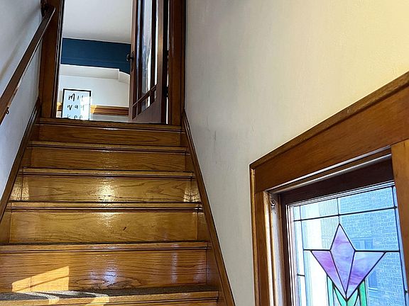 Stairs up into unit from front door, original stained-glass window facing south with brilliant light