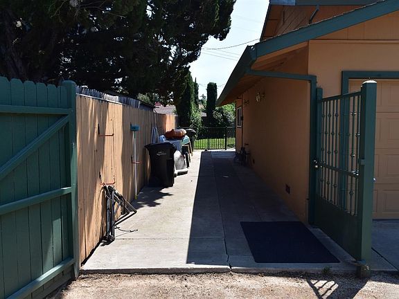 Top unit parking/storage and enters in gate on right of picture and left of garage to back yard and upstairs
