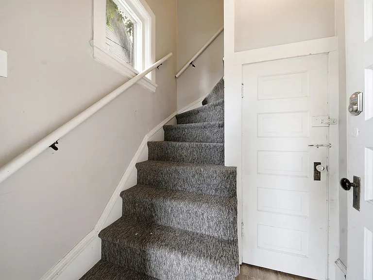Back entrance stairs. Small door shown leads to basement with private laundry and plenty of storage.