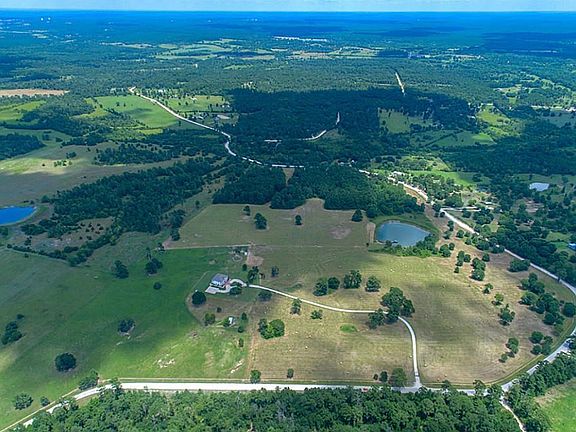 Strong cedar posts with five strand barb wire surround the entire property and there are 4 different entrances/exits. Beautiful improved pastures with scattered cedar, oak and Southern Pine trees and a tranquil pond welcome you to the property.