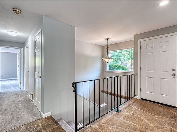 Recessed lighting illuminates the entrance with the hallway to the main floor bedrooms to your right and stairway to the daylight basement. 