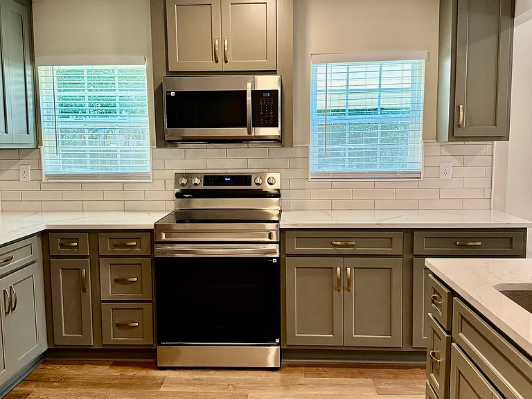 View 2 of kitchen showing off an adundance of natural light with windows overlooking new outside deck