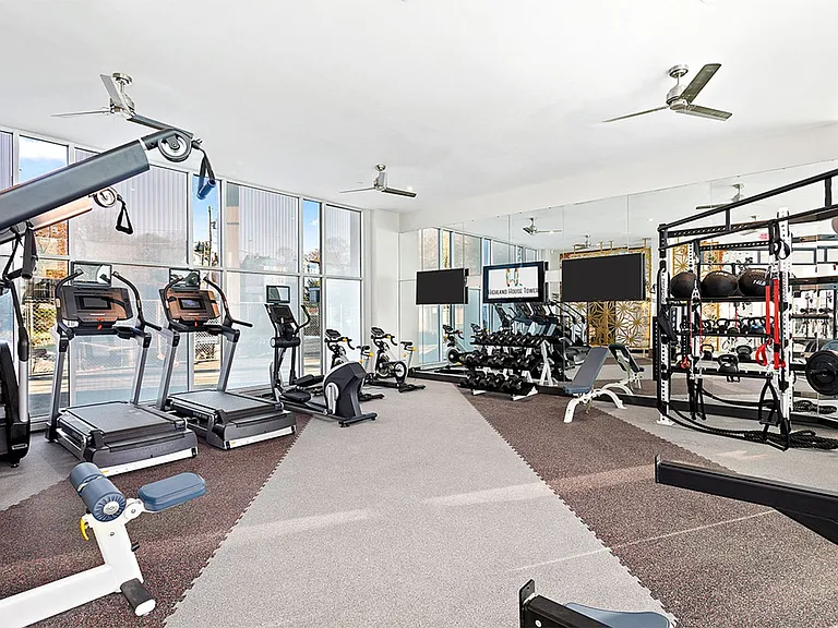 A gym with treadmills, weights, and exercise equipment.