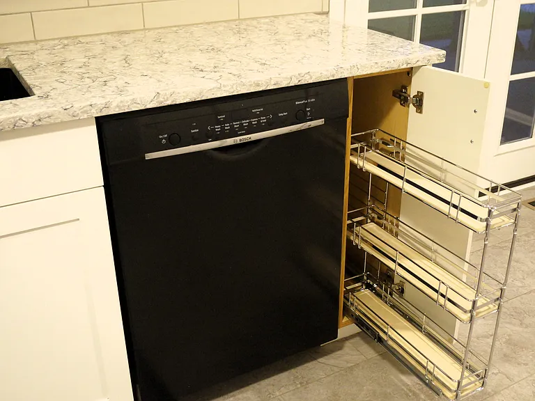 Pull out spice or storage rack and black Bosch dishwasher.
