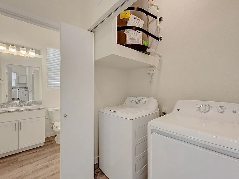 Experience the convenience of a well-designed laundry and bath combination in your living space.