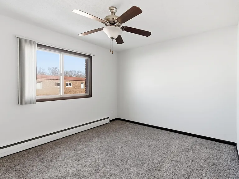 Welcome to St. Anthony Group, where modern comfort meets spacious living. This bright room features large windows, plush carpeting, and a ceiling fan for year-round comfort. Schedule your tour today and see your next home!