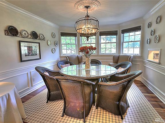 Formal dining room features crown molding, wainscoting, pass through to kitchen and black walnut hardwood floor.