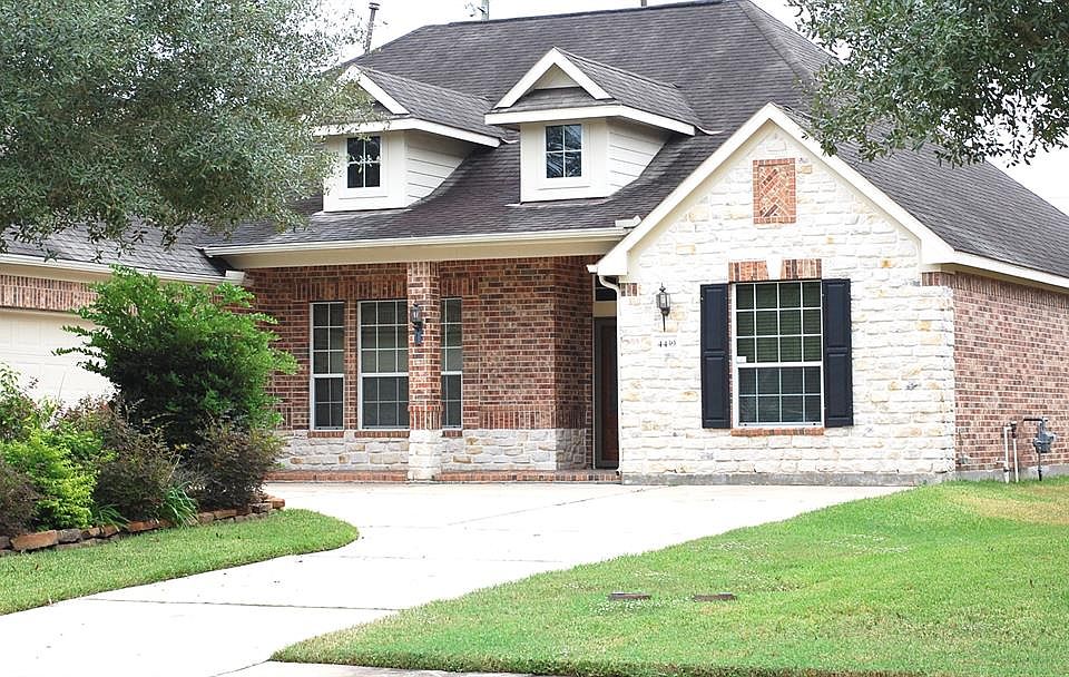 The front elevation of this 4 bedroom home includes both brick and stone
