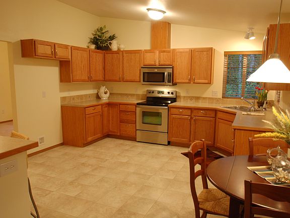 Large kitchen with stainless steel appliances, eating bar and nook.