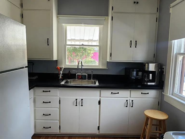 View with cabinets closed. The kitchen has a good amount of cupboard space and two windows.