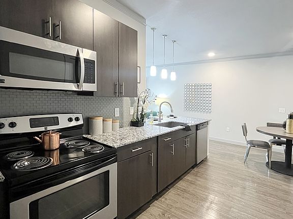 a kitchen with stainless steel appliances and a stove and microwave